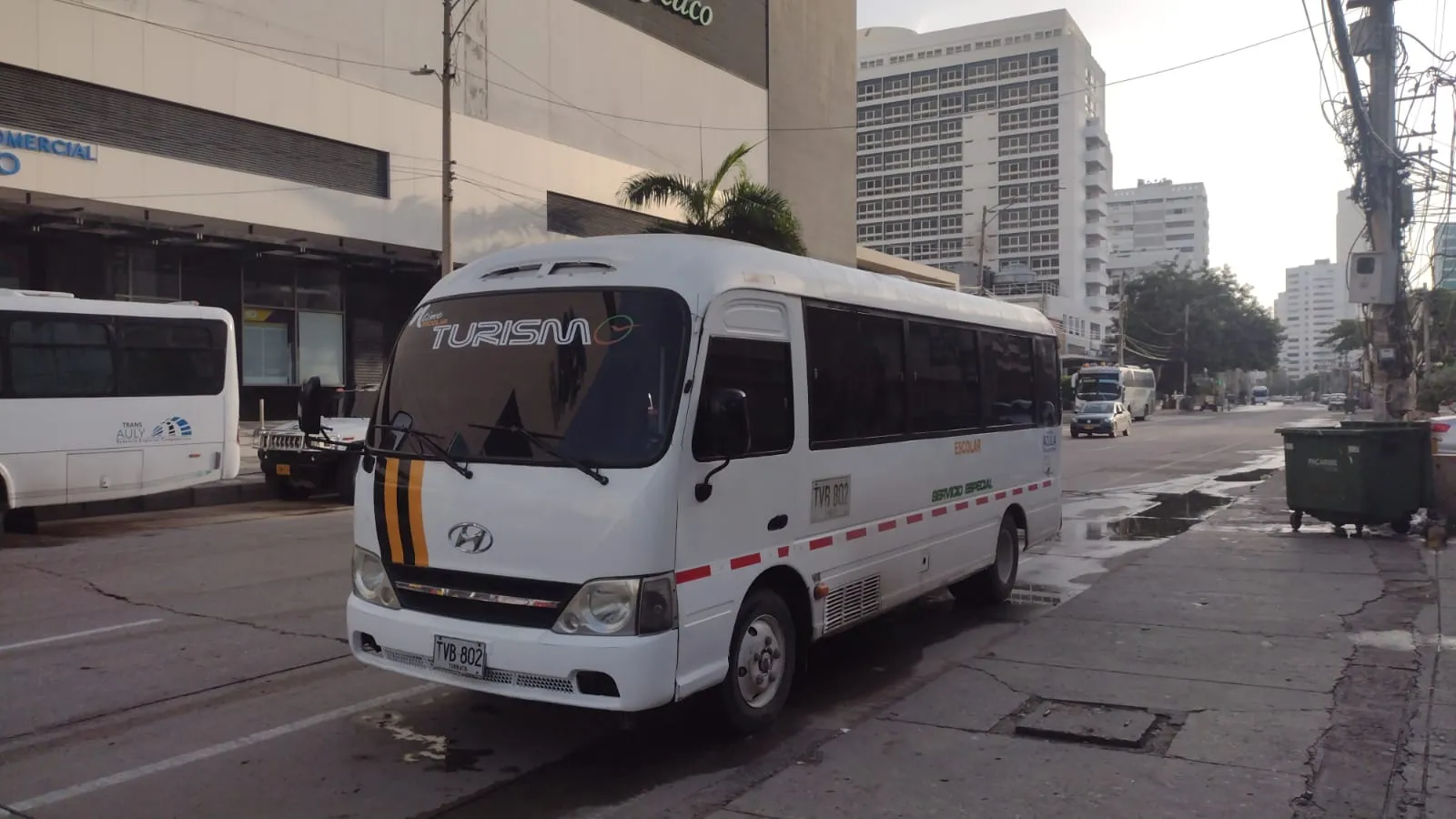 White minibus marked for private passenger service and tourism parked by the kerb